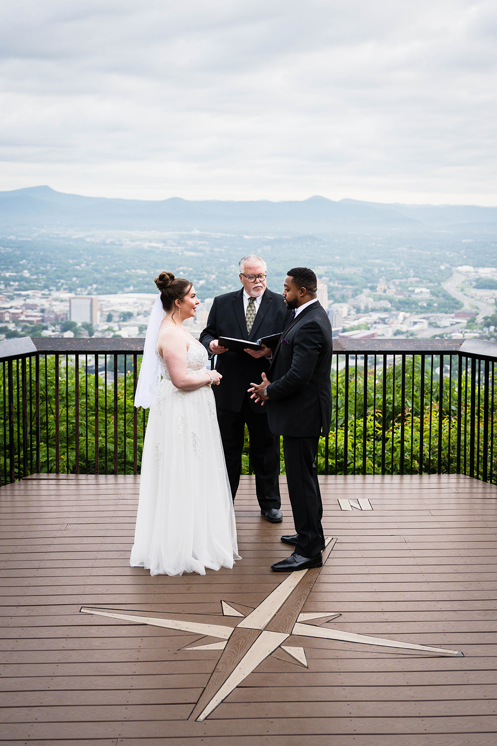 A couple stands in front of their officiant at the Mill Mountain Star Overlook during their elopement in Roanoke, VA.