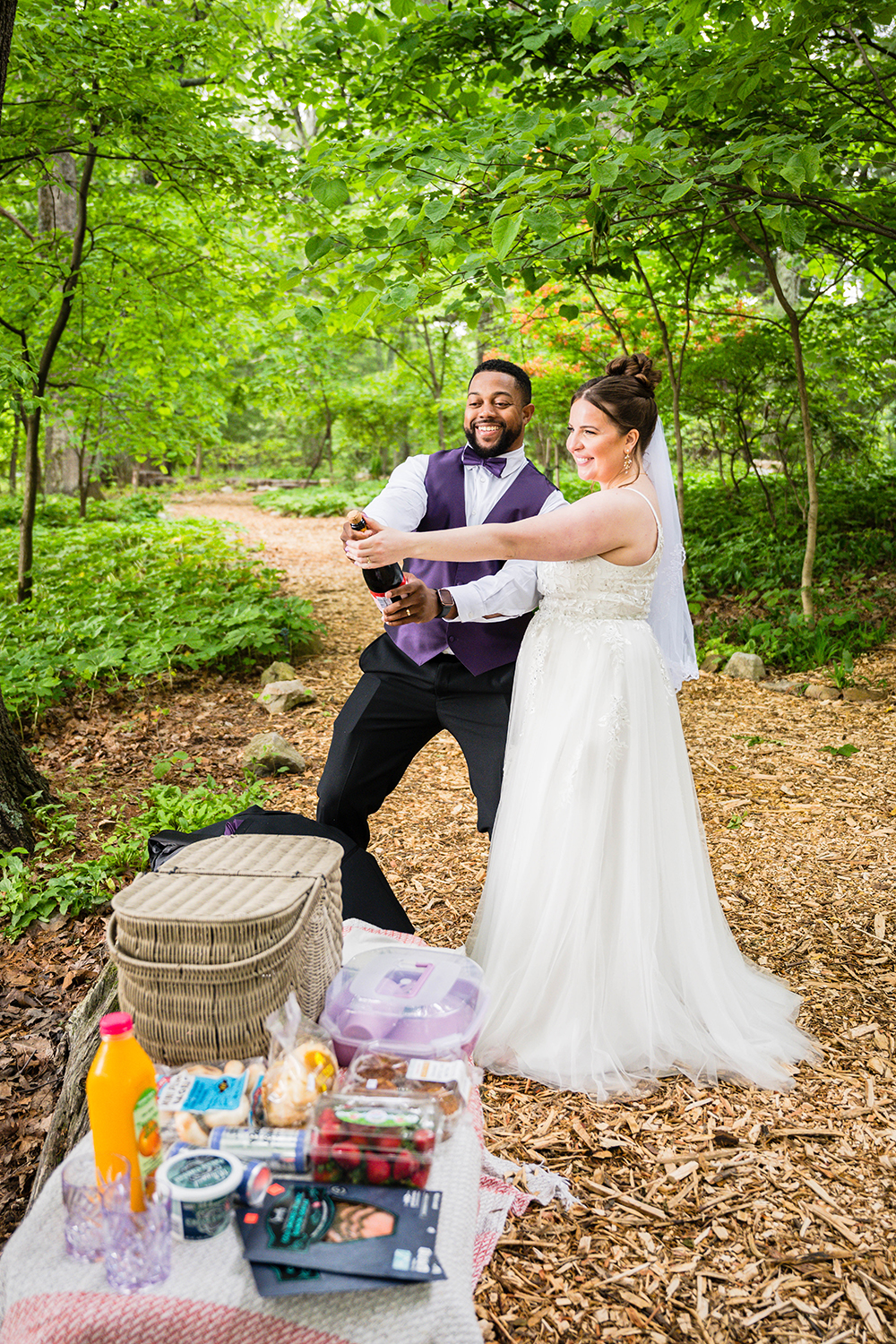 A couple prepares to pop a bottle of champagne in the Mill Mountain Wildflower Garden during their elopement in Roanoke, VA.