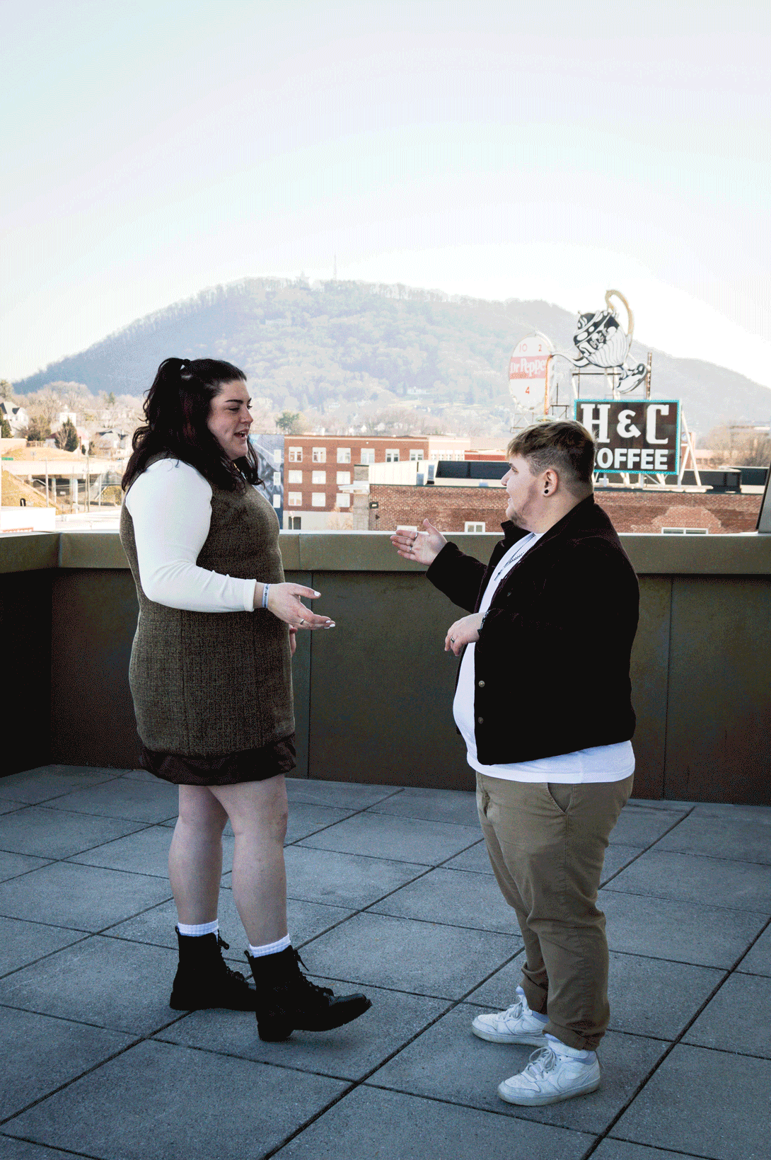 A GIF of an LGBTQ+ couple doing a special handshake on the balcony of the Taubman Museum of Art for their couples adventure session.