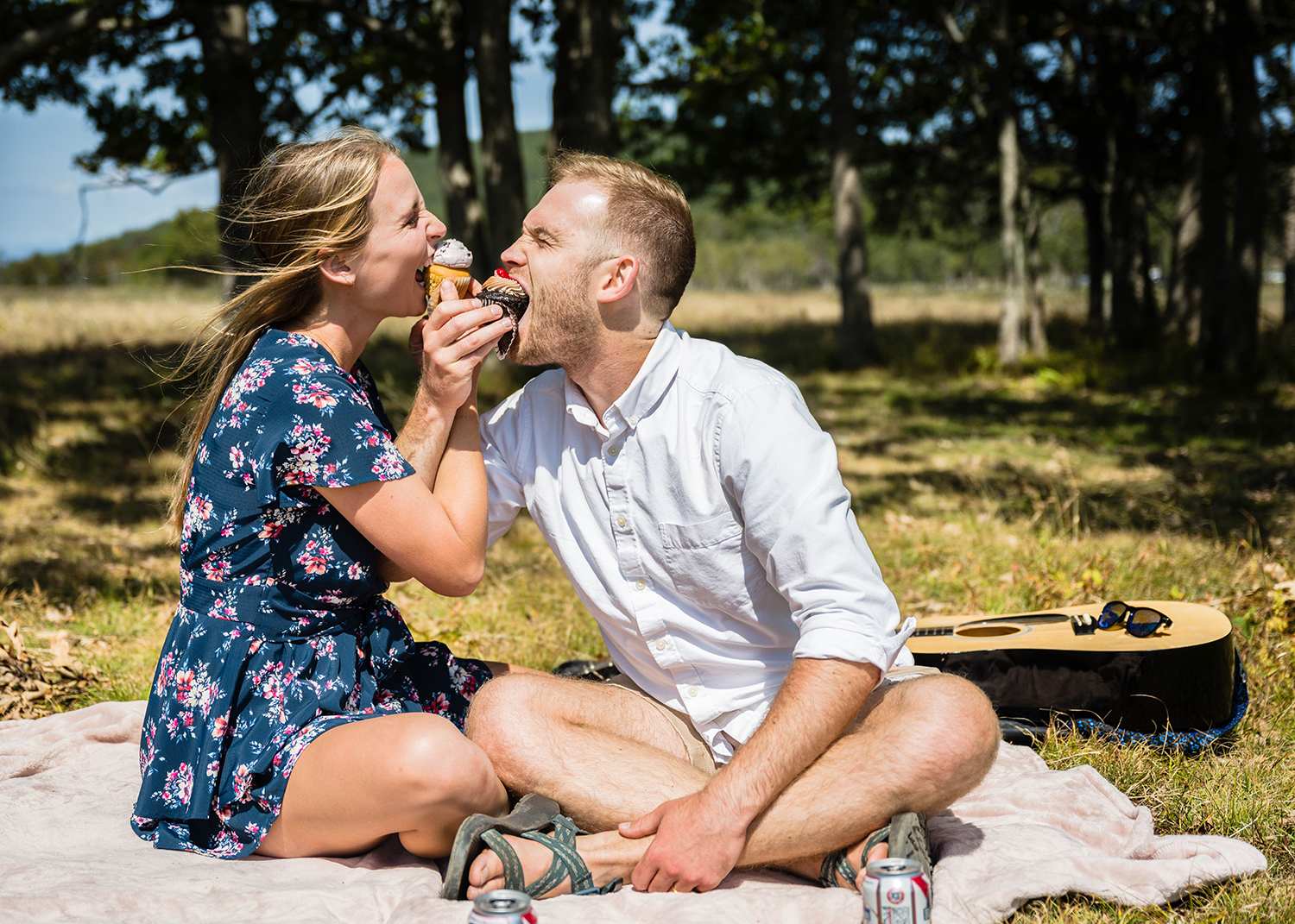 A wedding couple wraps their arms to feed each other their cupcakes on their elopement day in Shenandoah National Park.