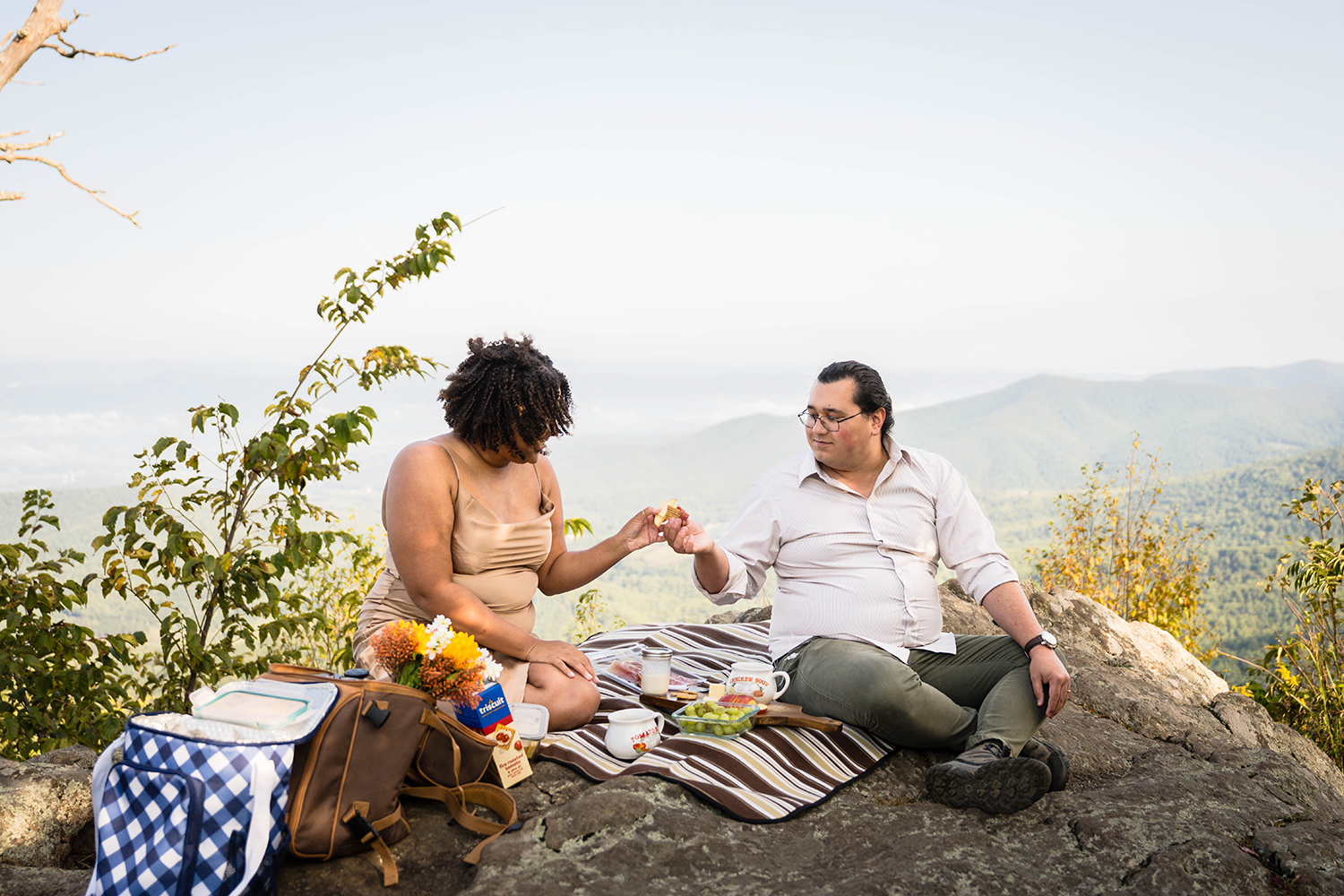 A couple "clinks" their breakfast snacks as they begin to eat their breakfast picnic at Jewell Hollow Overlook in Shenandoah National Park in Virginia. 