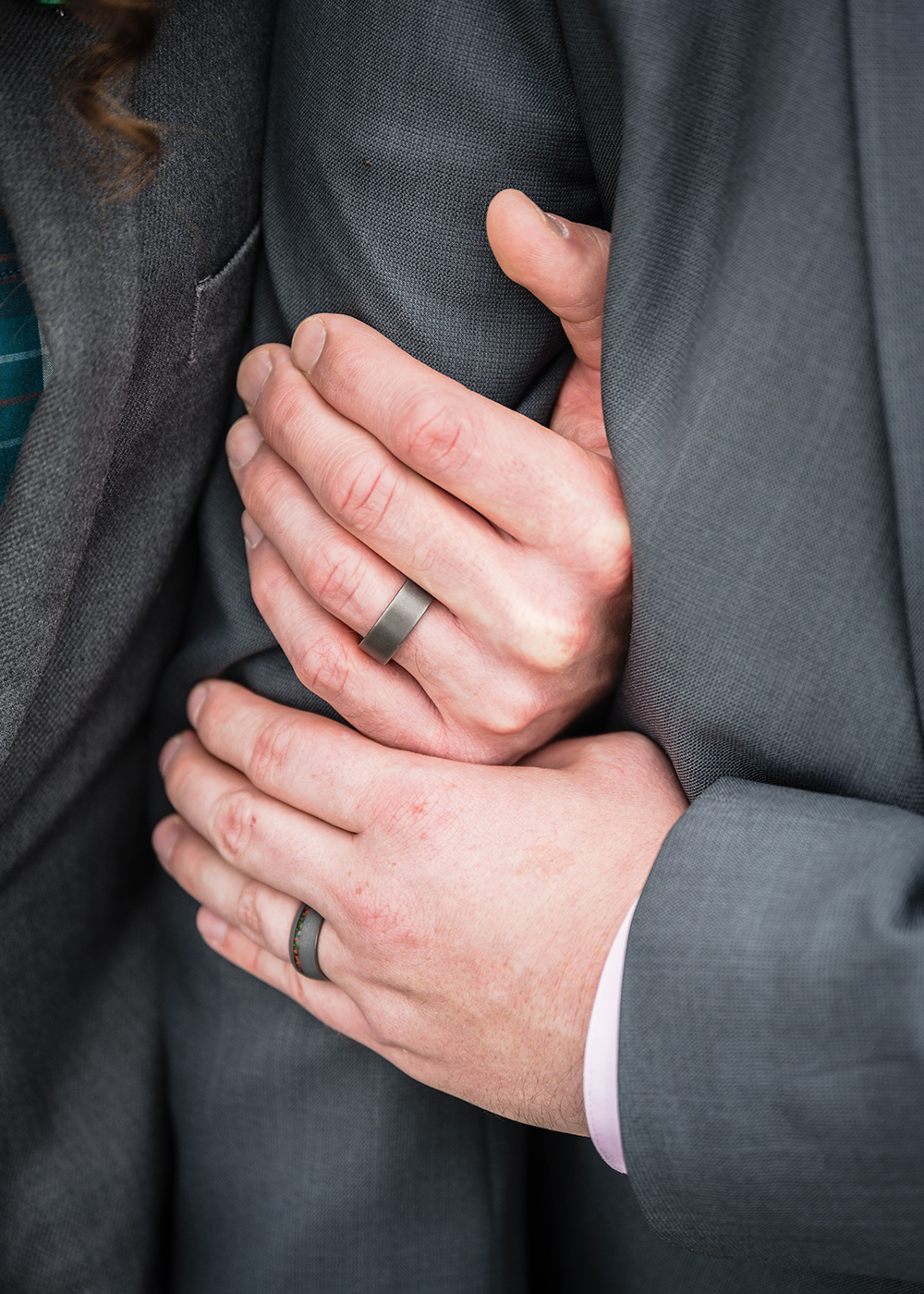 A close-up image of two individuals gently holding hands.