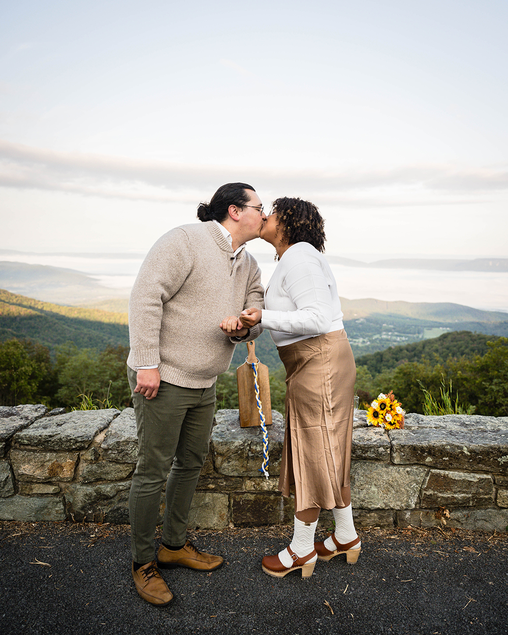 A couple on their elopement day goes in for their first kiss with their "pinky promise" still in tact. 