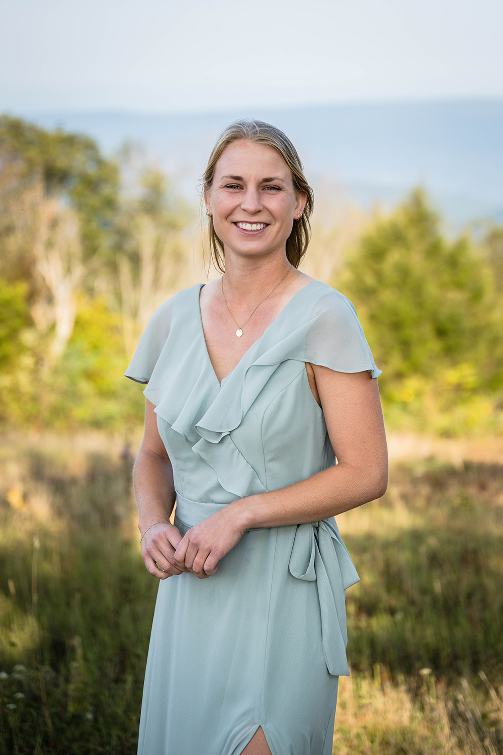 A marrier smiles for a photo in an open field at Tanner's Ridge Overlook in Shenandoah National Park in Virginia.