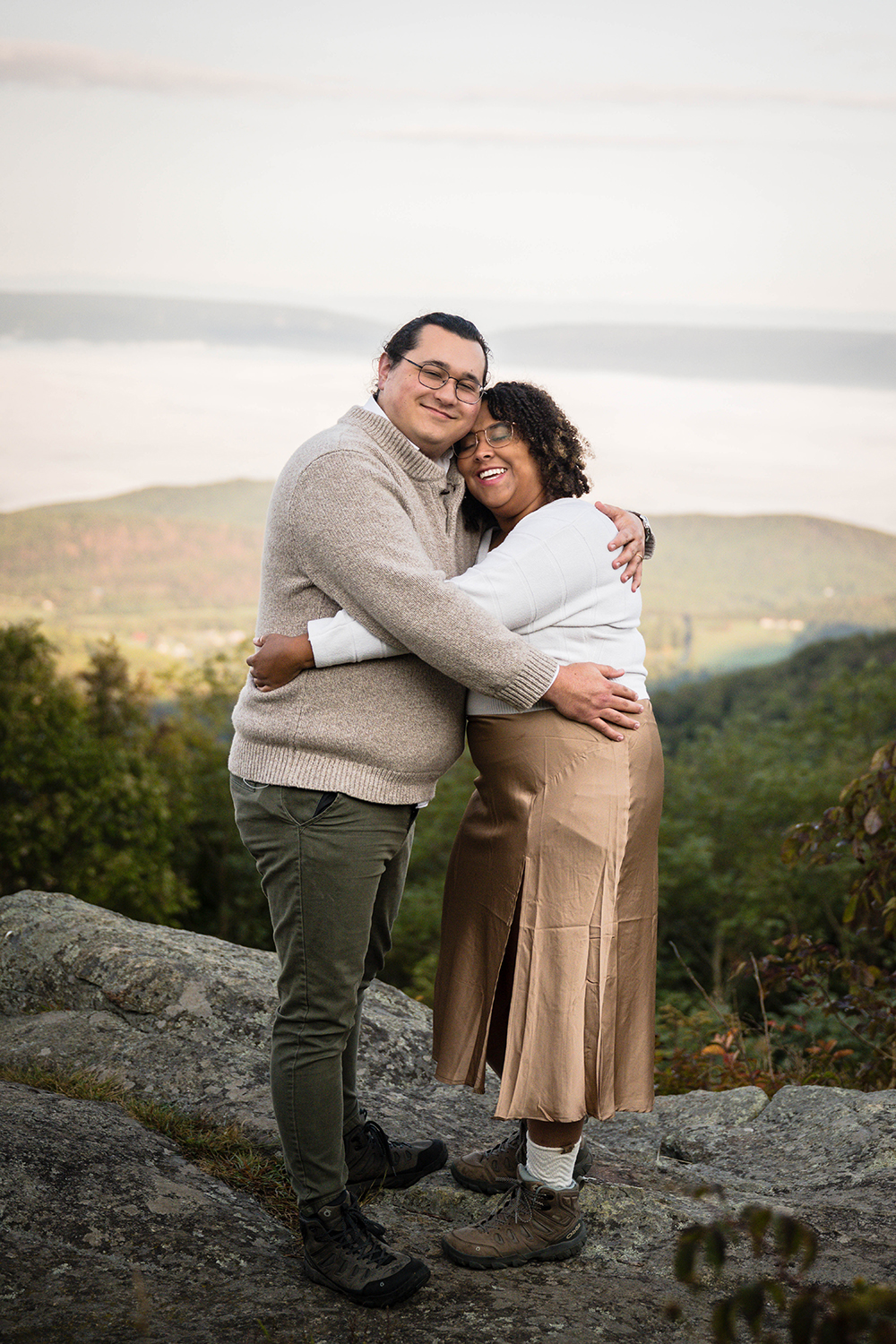 An elopement couple on their wedding day stand together and hug one another on a rock at Timber Hollow Overlook in Shenandoah National Park. 