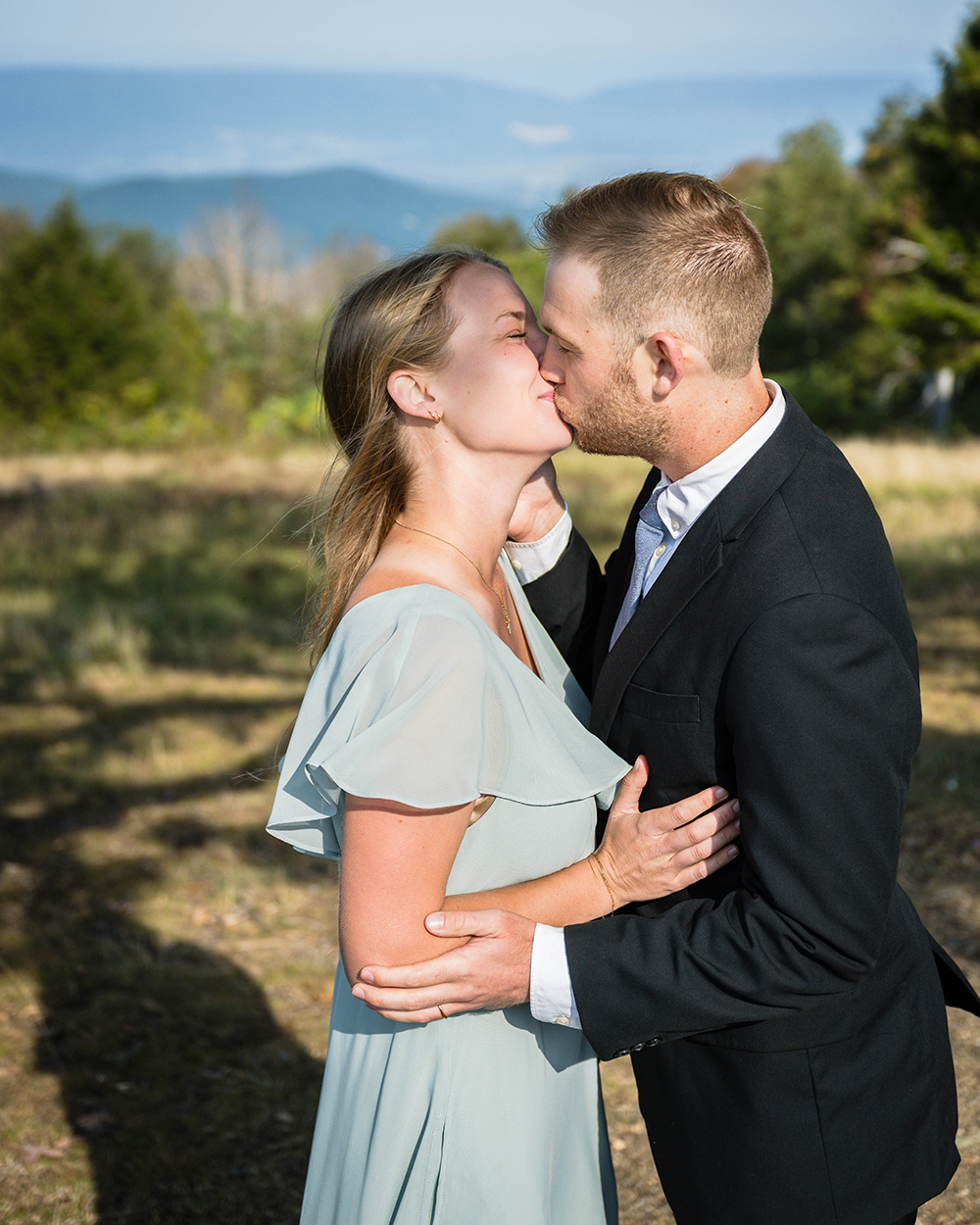 A wedding couple embrace and go in for their first kiss during their ceremony at Tanners Ridge Overlook in Shenandoah National Park.