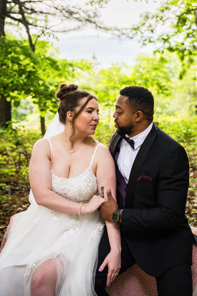 A couple sits on a small bench inside of a wildflower garden in Roanoke, Virginia on their wedding elopement day.