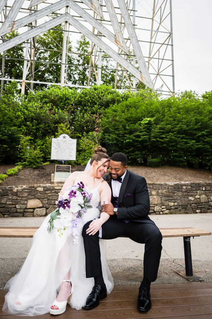 A couple on their elopement day sit on a bench in front of the iconic Roanoke Star.