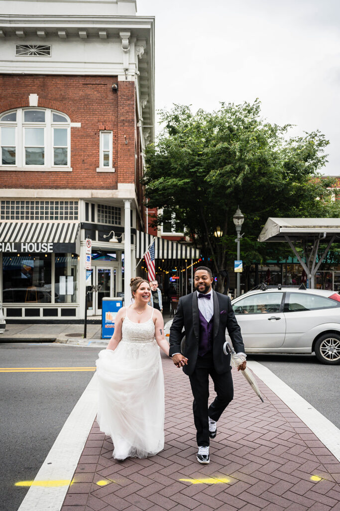 A couple on their Virginia elopement day walk hand-in-hand in Downtown Roanoke.