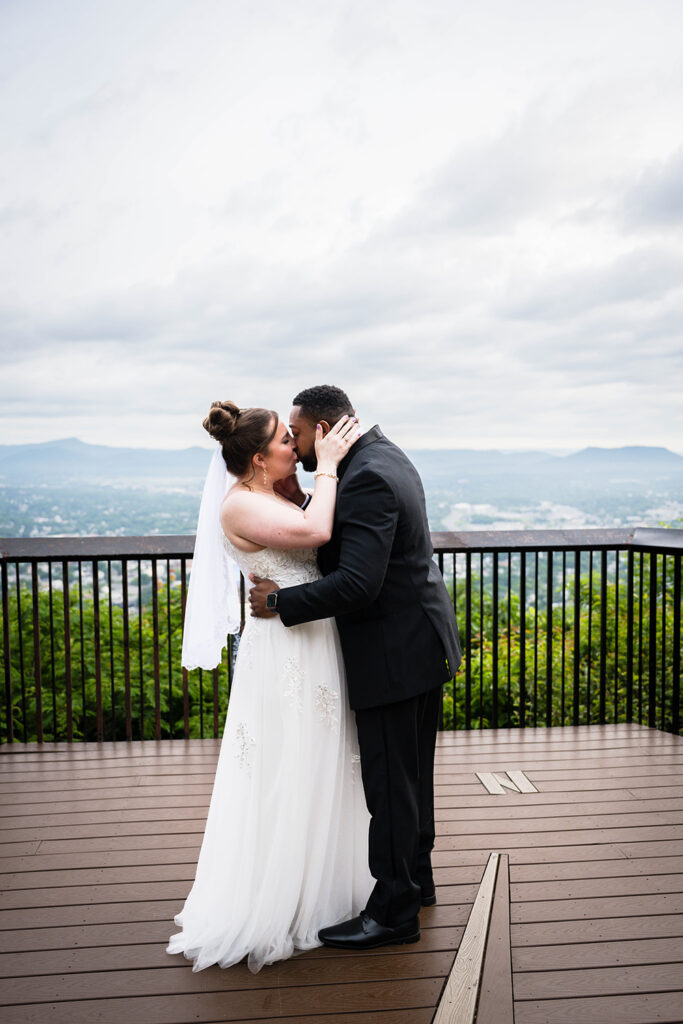 A man and woman kiss at Mill Mountain Overlook in Roanoke, Virginia on their elopement day.