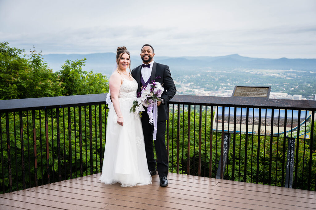 A couple on their elopement day stand together for a photo at Mill Mountain Star Overlook in Roanoke, Virginia.