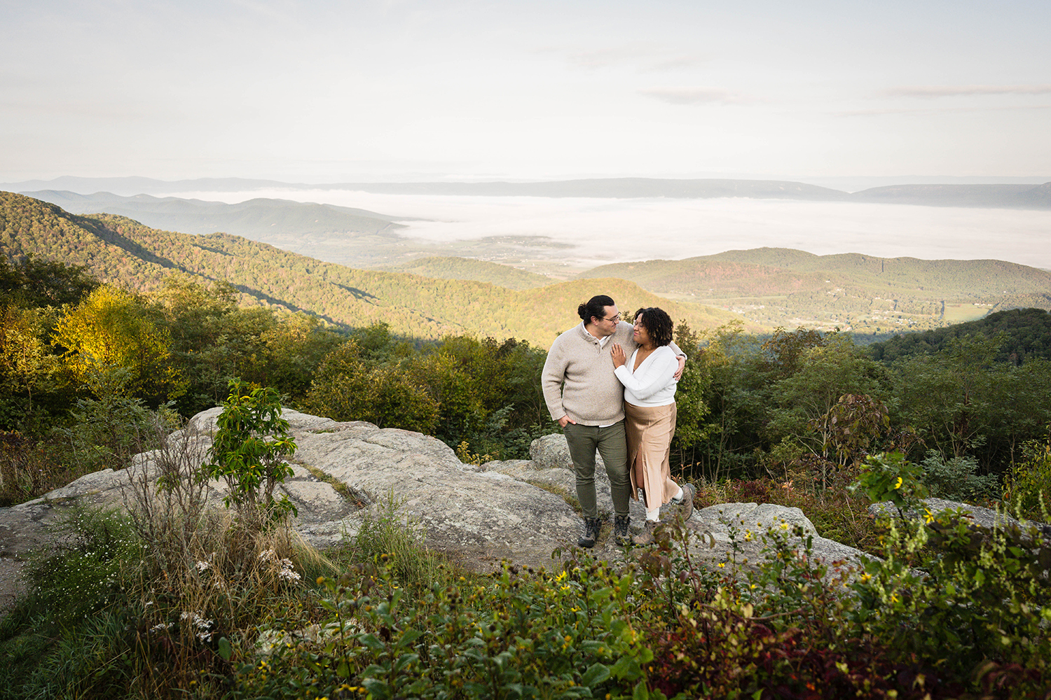 A couple stand together on a large rock at Timber Hollow Overlook in Shenandoah National Park on their intimate elopement wedding day.