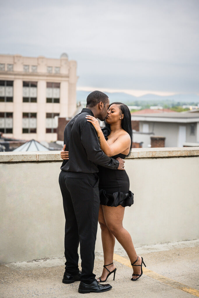 A Black couple kisses for their parking garage engagement photos in Roanoke, Virginia.