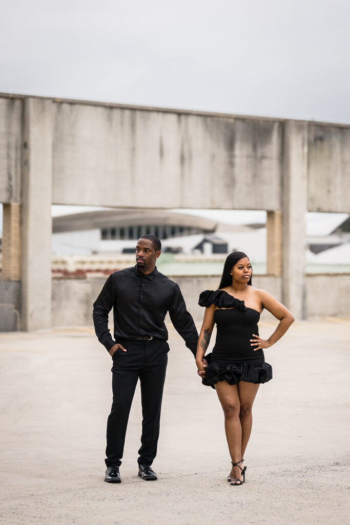 A Black couple hold hands their parking garage engagement photos in Downtown Roanoke.