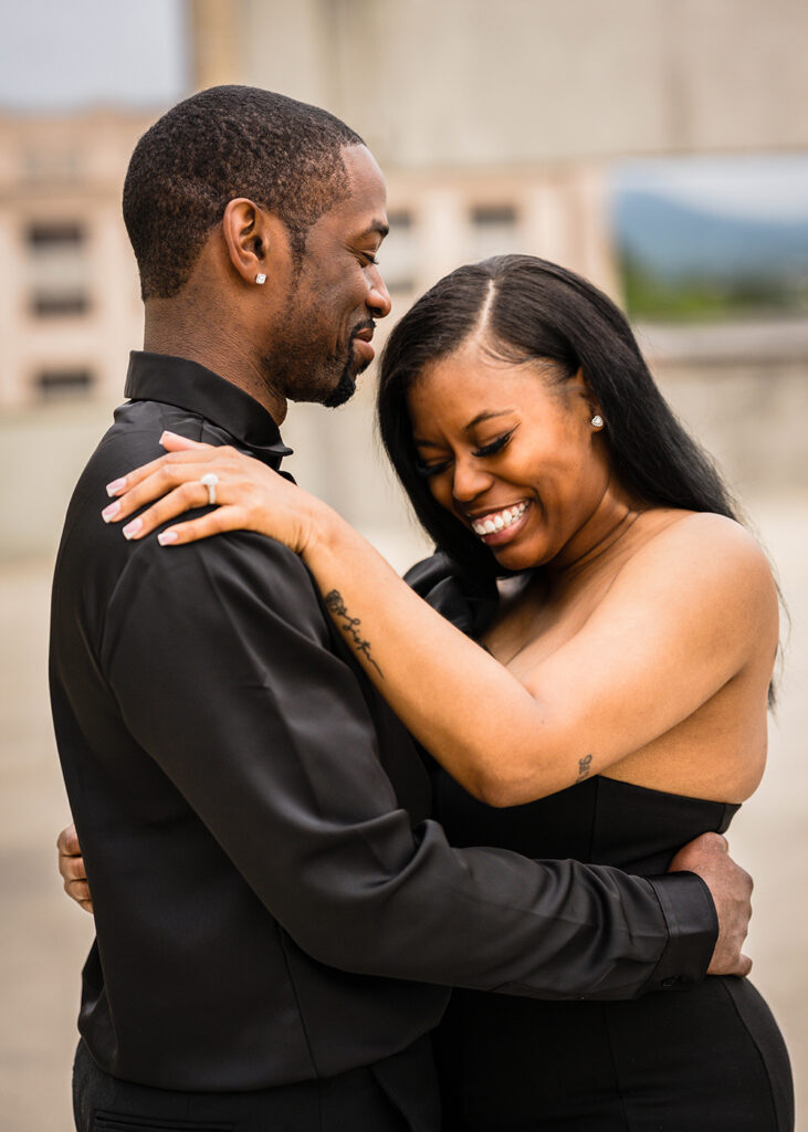 A Black couple embraces and both start to laugh a little in their embrace during their Roanoke engagement session.