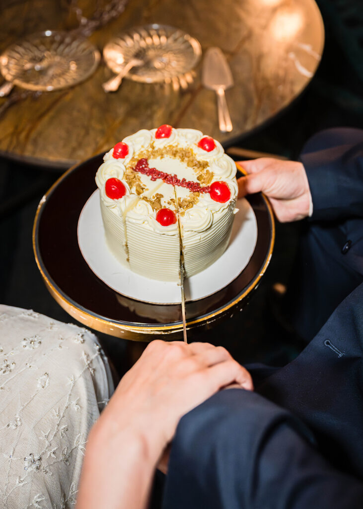 A close up photo of a wedding cake from Evie's Bistro & Bakery being cut into by a couple on their elopement day in Roanoke, Virginia.