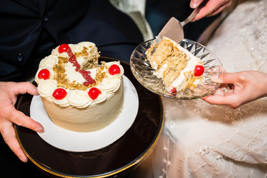 A close up photo of a wedding cake from Evie's Bistro & Bakery being cut into by a couple on their elopement day in Roanoke, Virginia.