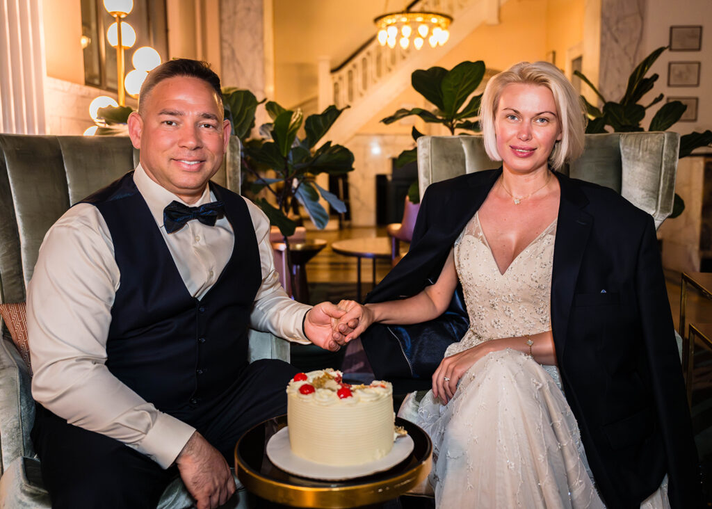 A couple sits in the lobby of the Liberty Trust hotel after cutting into their cake on their wedding day.