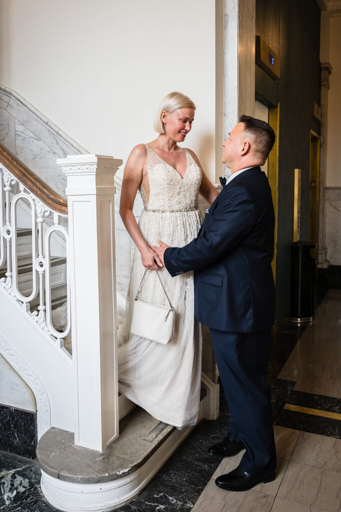 A couple has their first look on their wedding day on a stairwell in the Liberty Trust Hotel in Roanoke, Virginia.