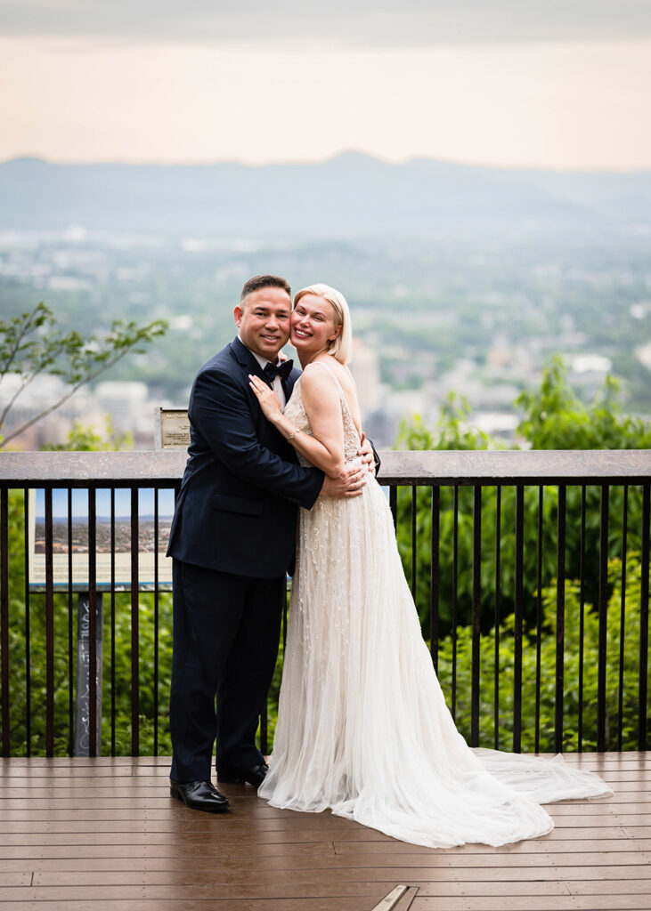 A couple poses together on their elopement day at Mill Mountain Star Overlook in Roanoke, Virginia.