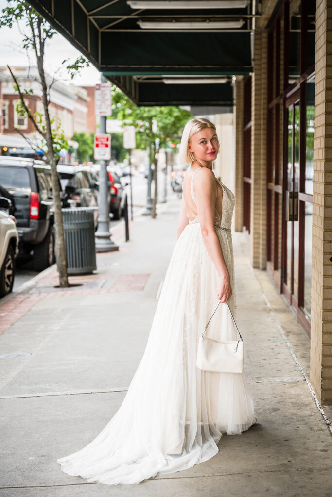 A woman shows off her wedding dress and purse on her elopement day in Roanoke, Virginia.