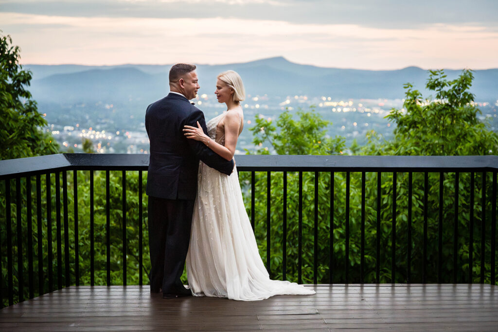 A wedding couple embraces one another at Rockledge Overlook in Roanoke, Virginia during blue hour.