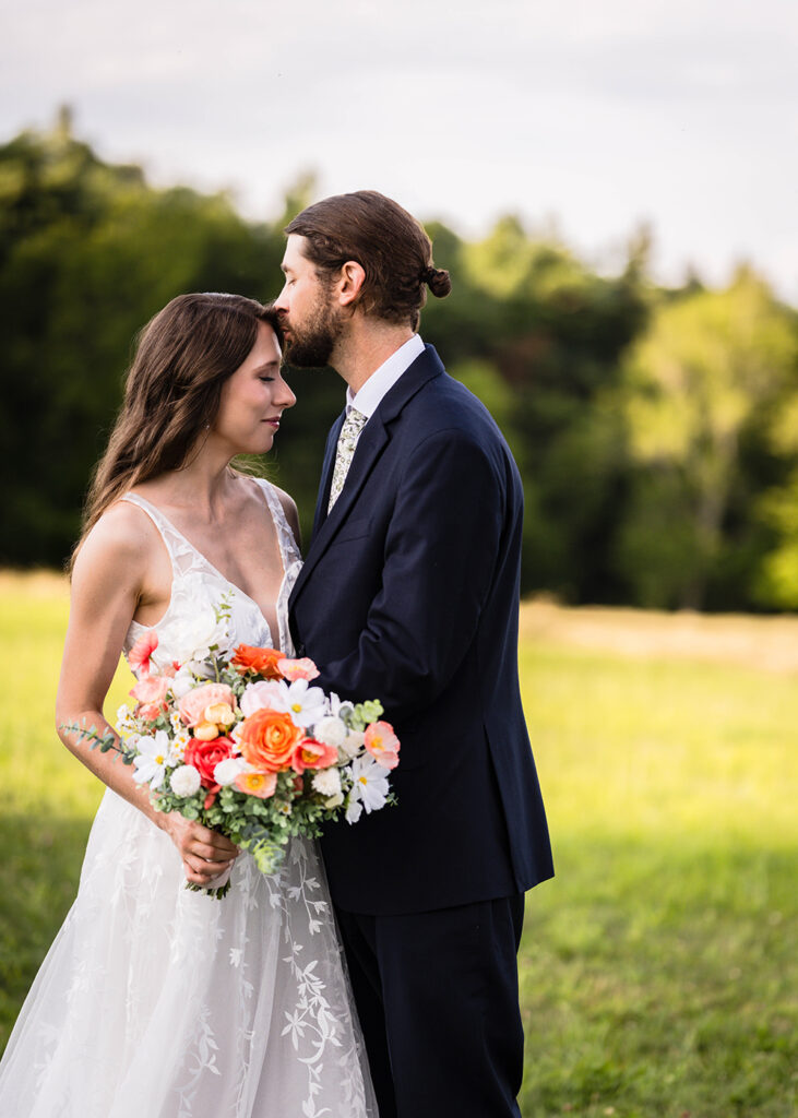A marrier kisses the forehead of his partner during golden hour at Cahas Mountain Overlook.
