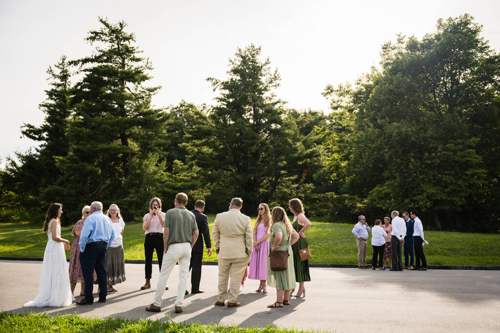 Wedding guests for a Blue Ridge mountain elopement form two circles and talk with one another after a wedding ceremony at Cahas Mountain Overlook.