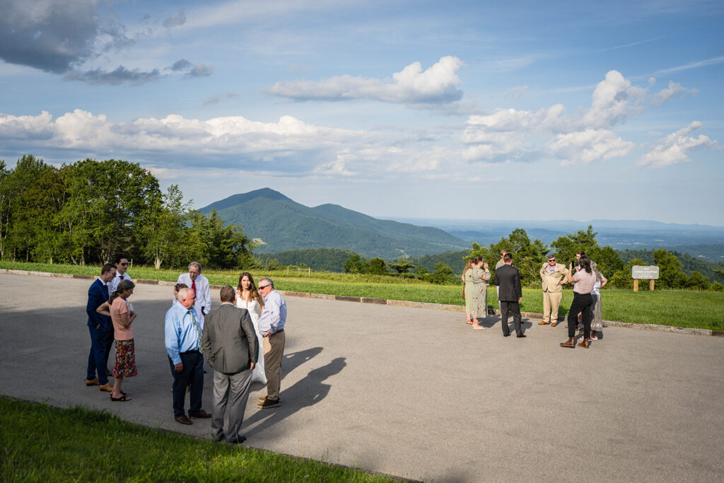 Wedding guests for a Blue Ridge mountain wedding form two circles and talk with one another after a wedding ceremony at Cahas Mountain Overlook.