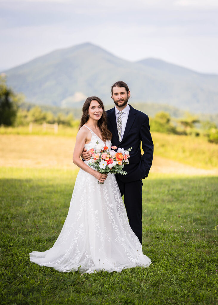 An elopement couple pose together for a wedding portrait at golden hour in front of Cahas Mountain.