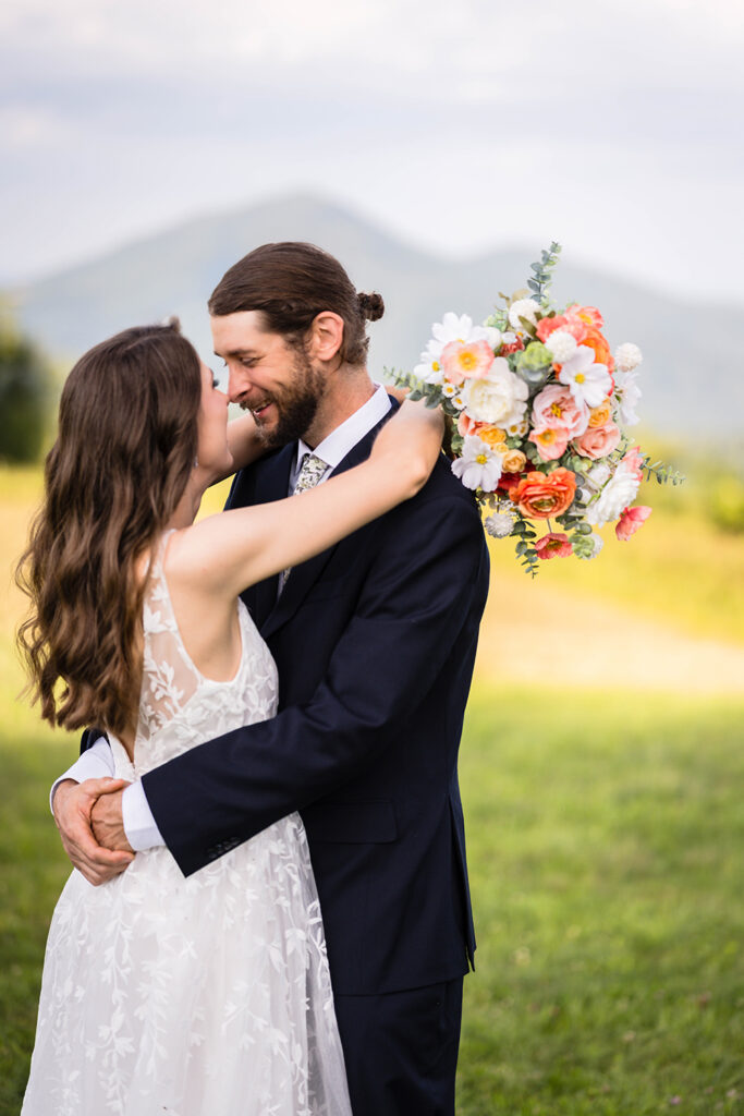 A wedding couple goes in for a kiss during their wedding portrait session at Cahas Mountain Overlook.
