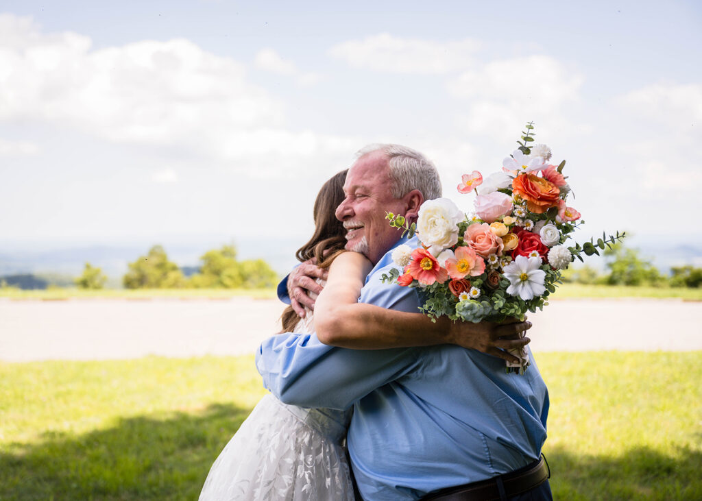 A bride on her Blue Ridge Parkway elopement day hugs her Dad after their first look.