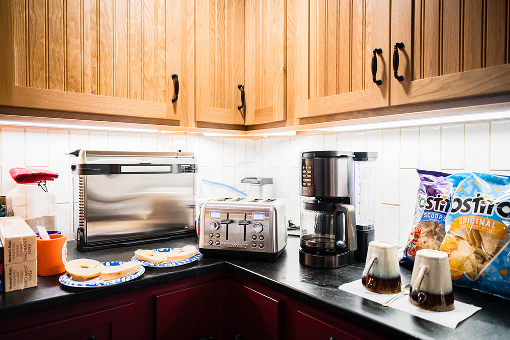 Kitchen appliances, like a toaster and a coffee machine, placed on a kitchen countertop.