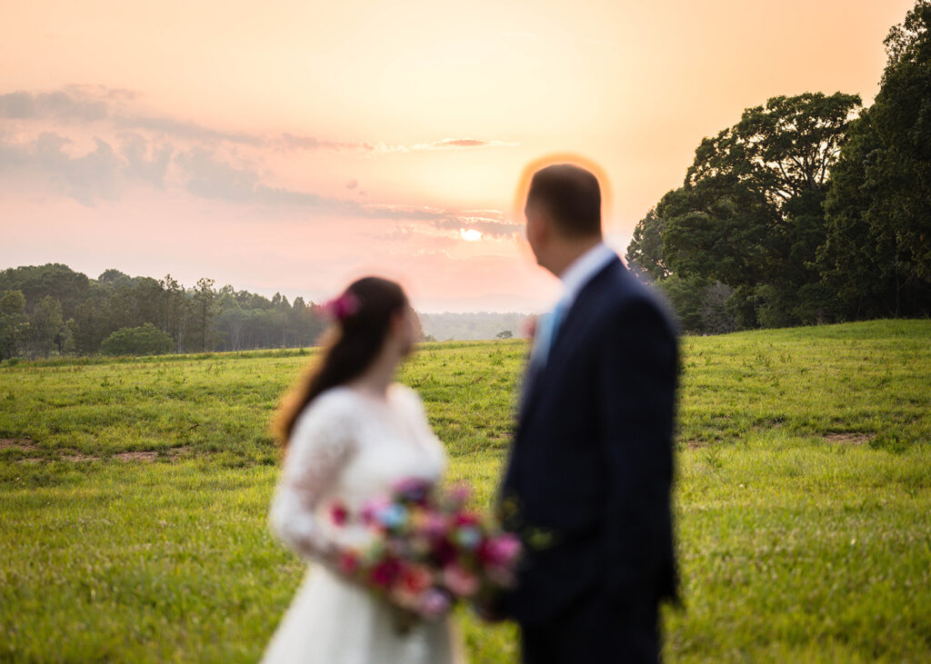 An intentionally out-of-focus couple look back to see the sun begin to set during their Martinsville, Virginia elopement day.