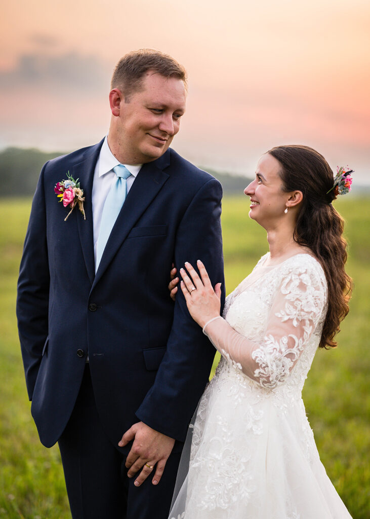 A man and woman smile at one another during their golden hour Martinsville, Virginia elopement portrait session.