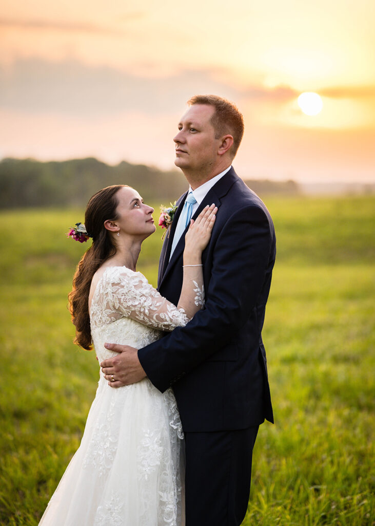 A woman looks up at a man and the man looks off in the distance for a dramatic photo during the couple's portrait session on their elopement day in Martinsville, Virginia.
