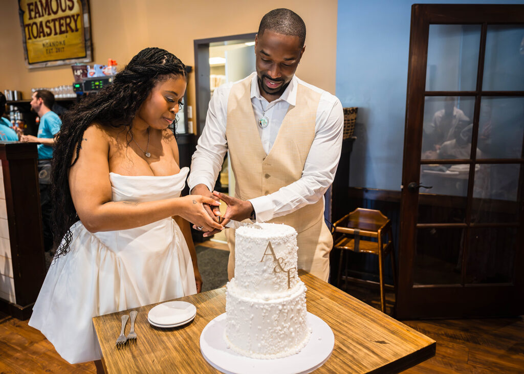 A Black wedding couple cuts into their cake at Famous Toastery in Roanoke, Virginia.