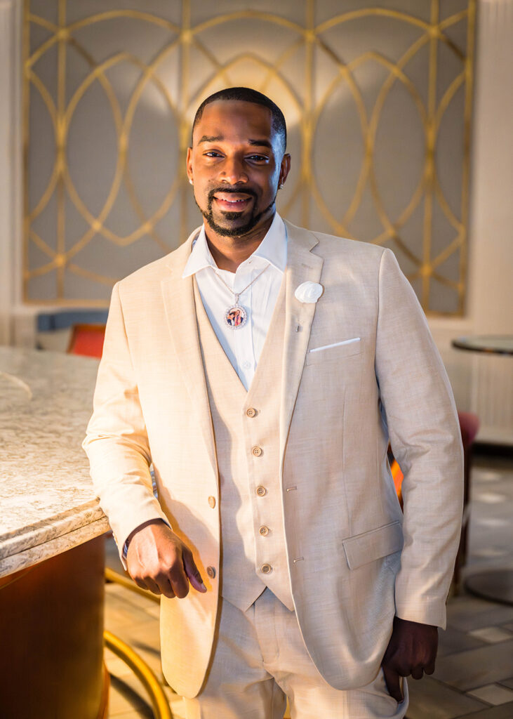 A man wearing a tan suit poses for a photo on his wedding day in Downtown Roanoke.
