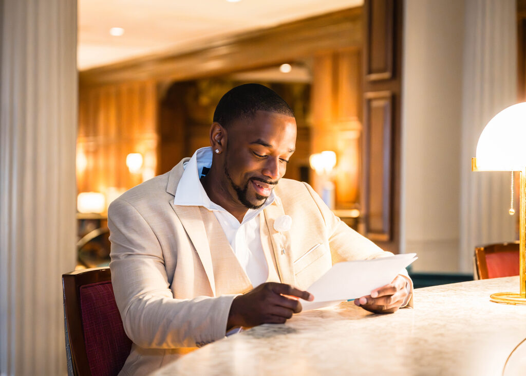 A man reads the vows his soon-to-be wife wrote to him at the bar in Hotel Roanoke.