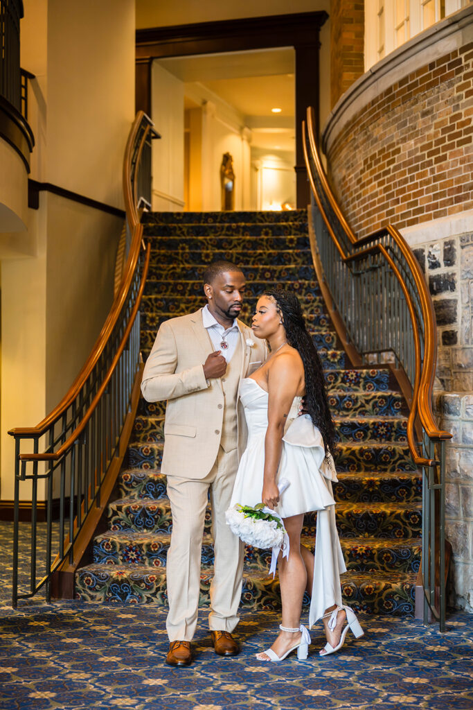 An elopement couples poses at the base of the Hotel Roanoke grand staircase for a dramatic photo for their Downtown Roanoke wedding.