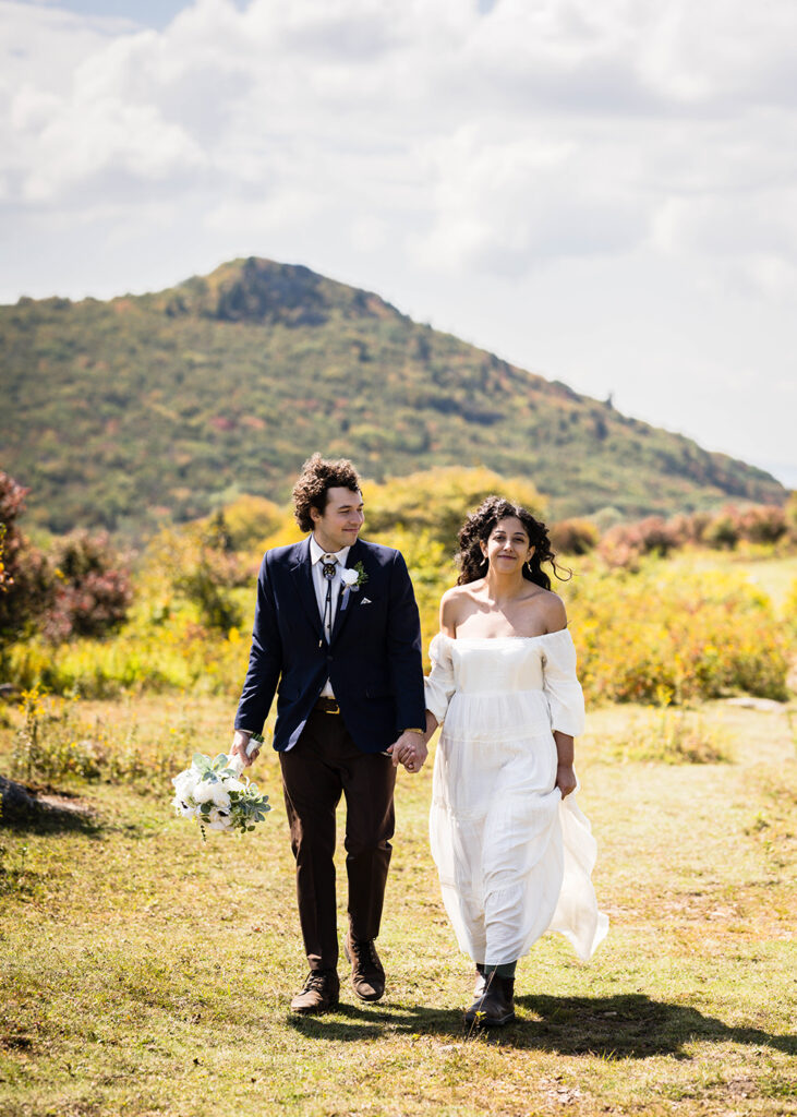 A wedding couple walk hand-in-hand in Massie Gap for their Grayson Highlands State Park elopement.