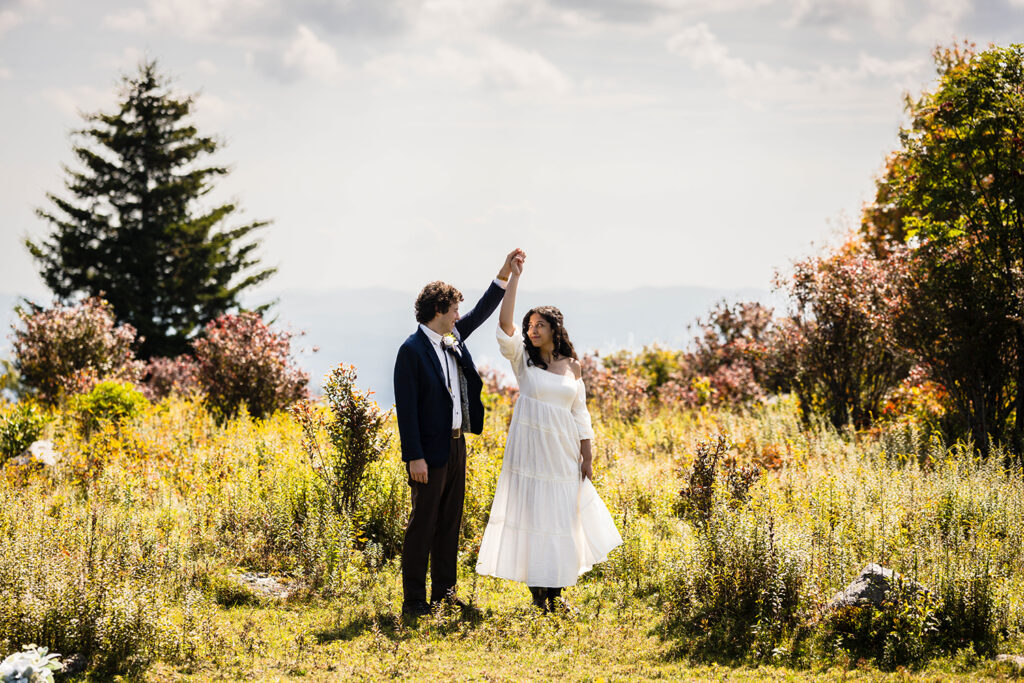 A man twirls his significant other while she holds onto her dress in a private area of Massie Gap.