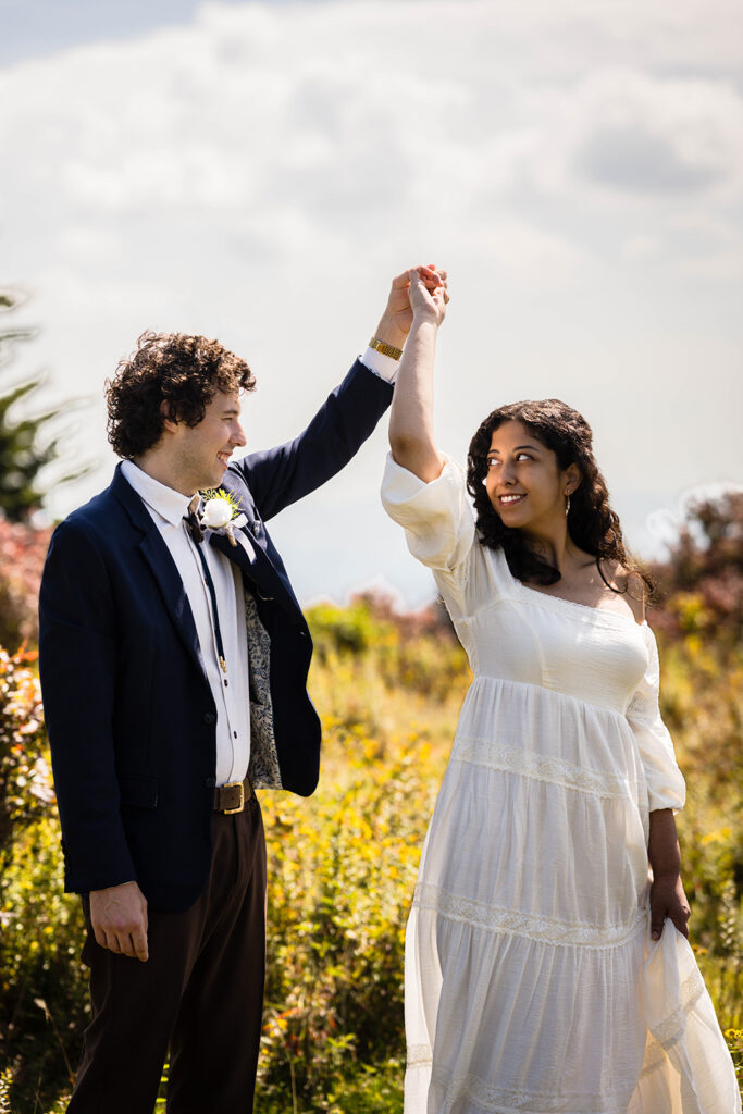 A marrier twirls his partner as she holds onto her dress in a private area of Massie Gap.