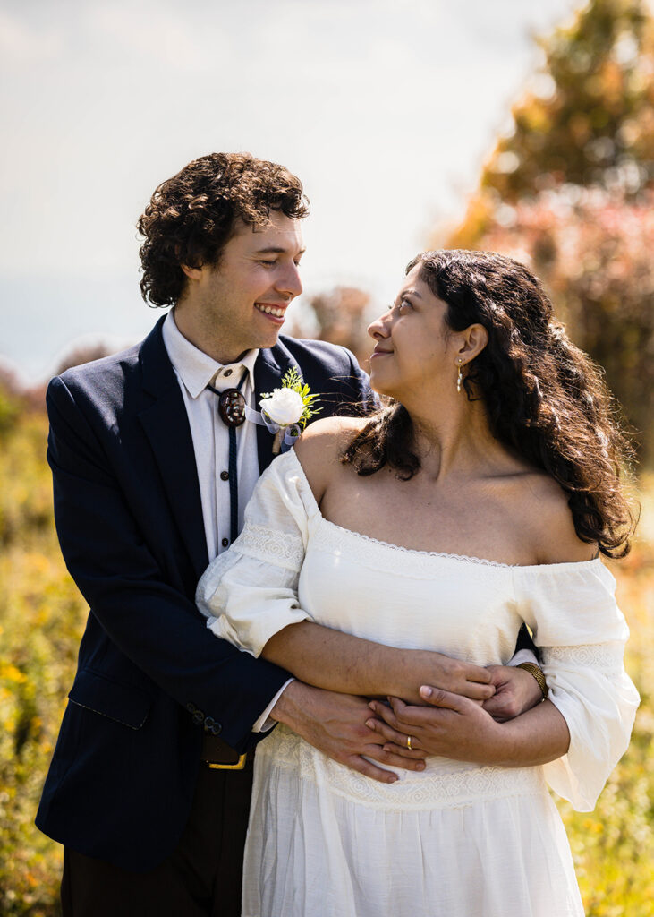 A wedding couple pose together in Massie Gap for their Grayson Highlands State Park elopement.