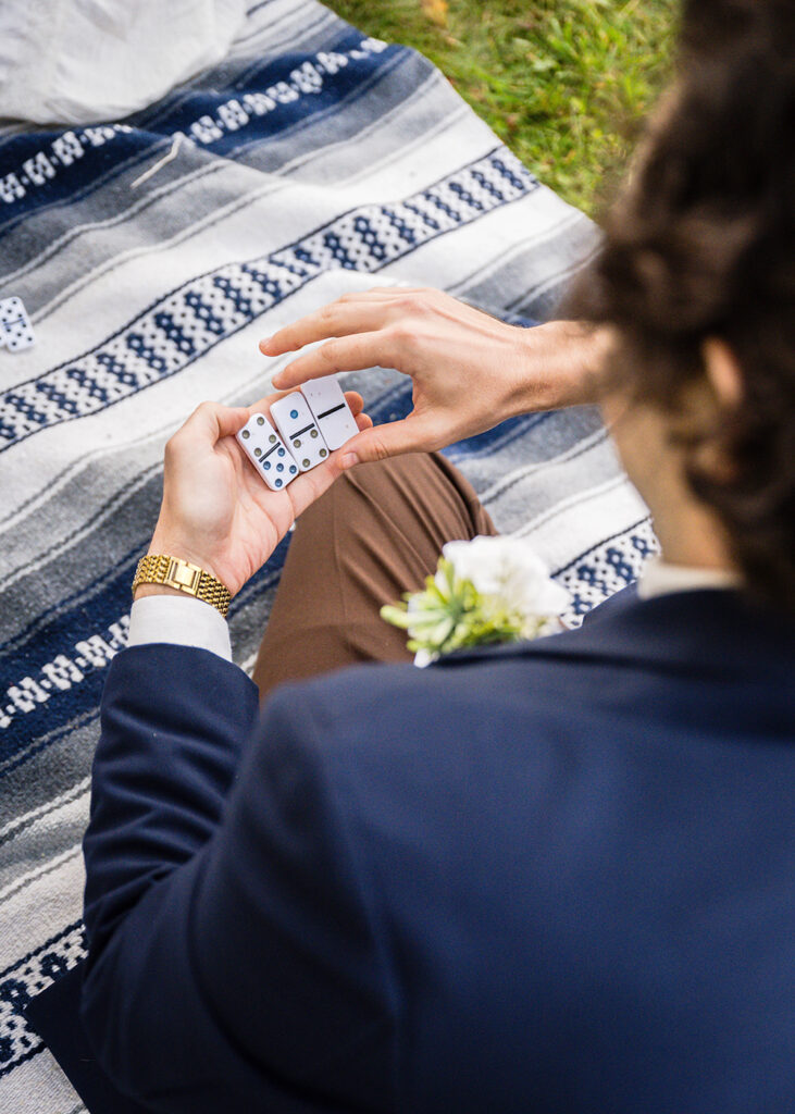 A man looks at his hand to view his options for a game of dominos.