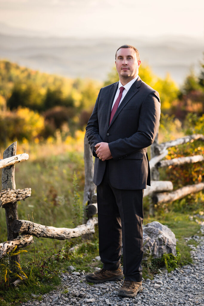 A groom poses for a photo along the Massie Gap trail on his elopement day.