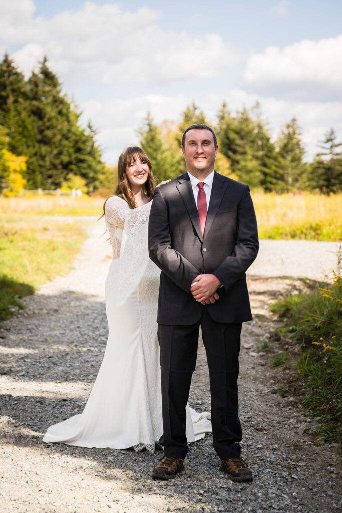 A wedding couple gets ready for their first look on a walking trail in Grayson Highlands State Park.
