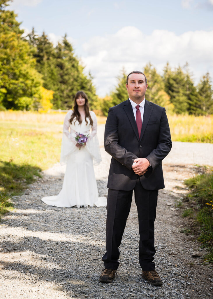 A wedding couple gets ready for their first look on a walking trail in Grayson Highlands State Park.