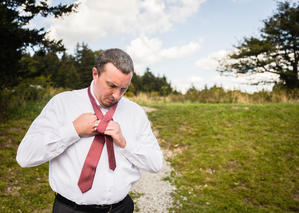 A man ties a tie in Grayson Highlands State Park.