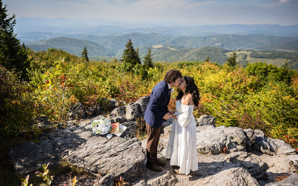 A couple goes in for their first kiss as husband and wife at Little Pinnacle Overlook for their Grayson Highlands State Park elopement.